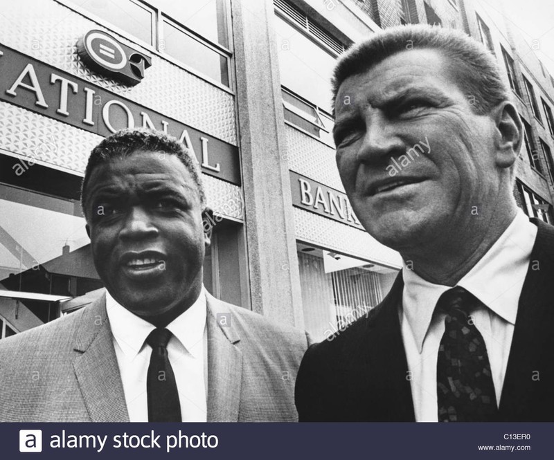 Jackie Robinson, with Robert Preston in front of the Freedom National Bank in Harlem, 1965 -