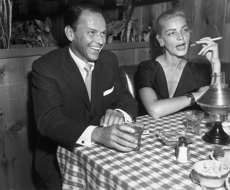 Singer and actor Frank Sinatra with actress Lauren Bacall at Musso and Frank, 1957