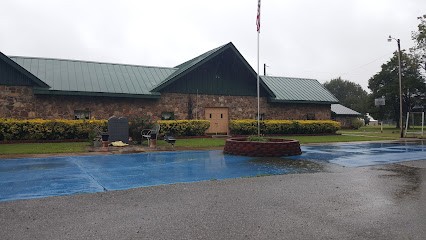 A colored photo of the front and parking lot of a church.