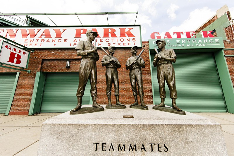 The statue as seen with Fenway Park's Gate B in the background, the pedestal inscribed with the word "Teammates" can be seen the the foot of the image