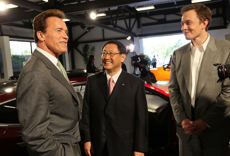 Former California Governor Arnold Schwarzenegger (left) meets with Tesla Motors CEO Elon Musk (far right) and Toyota CEO Akio Toyoda meet to commemorate the sale of the former NUMMI facility to Tesla in 2010. Getty Images.