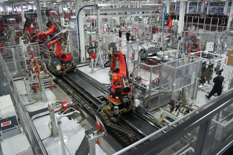 A publicity still from the Tesla Factory's interior, showing the high degree of robotic automation in the plant. Despite the application of new technology, Tesla's current output remains only a fraction of NUMMI's.
