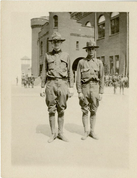 Photograph of two World War I soldiers posed in front of the Red Gym in Madison, Wisconsin.  