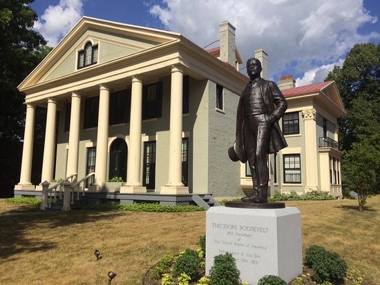 A Statue of Theodore Roosevelt Stands In Front of the Historic Home 