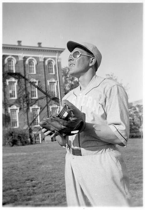 An unidentified baseball player with the University Building in the background.  ca. 1930s.  EKU Photograph Collection.