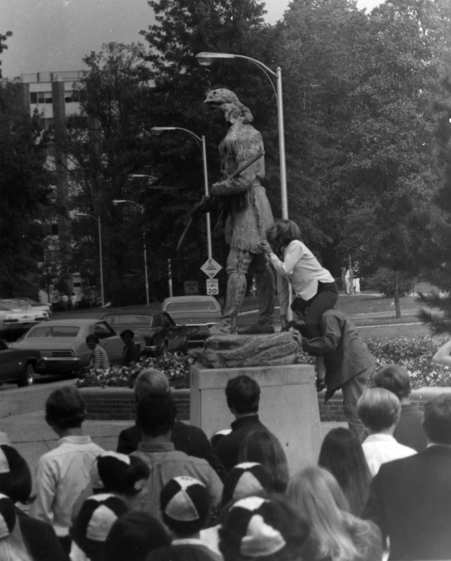 Freshman girl kissing the butt of the Daniel Boone statue during rat court, a hazing of freshman, 1969. EKU Photo Collection.