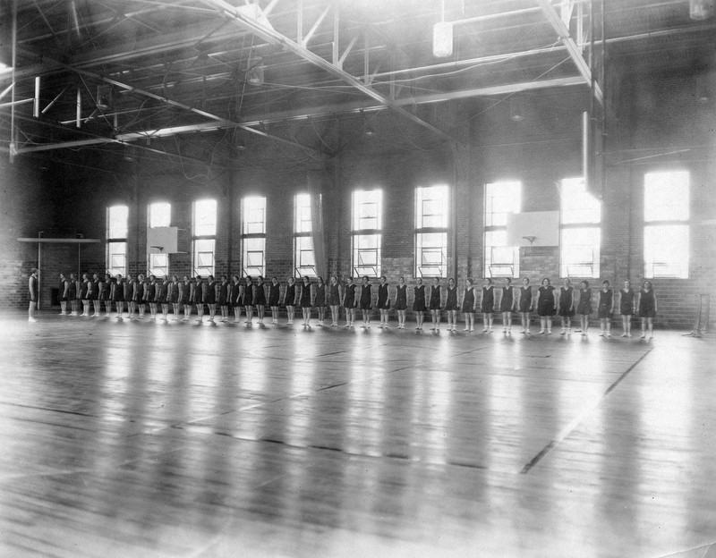 Girls lined up along the edge of the basketball court in Weaver Gym, 1935. EKU Photo Collection.