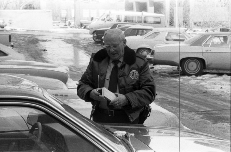 One of EKU's lot guards writing parking tickets, 1984.  EKU Negative Collection.