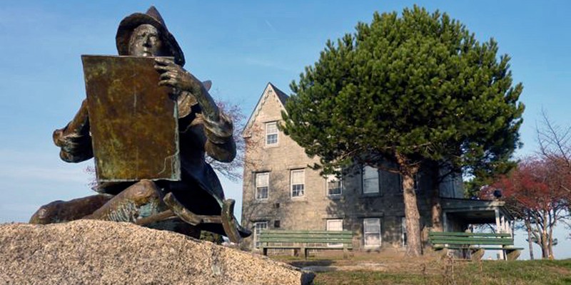 Statue of Fitz Henry Lane with his home in the background 