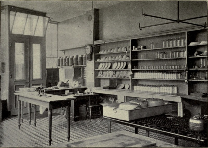 The shelves on the wall are full of dishes and various pots and tools are arranged around the room.