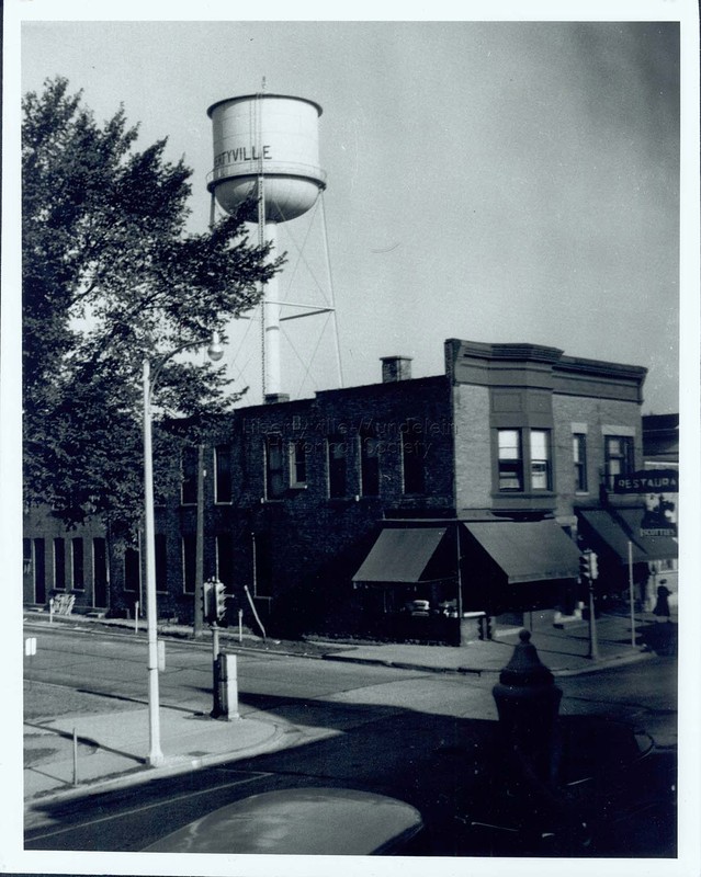 Titus Brothers and Scottie's Restaurant with old village water tower in background, 1948