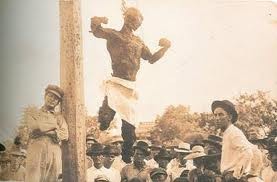 A postcard commemorating the lynching; written on the back: “This is the barbecue we had last night. My picture is to the left with a cross over it. Your son, Joe [Myers].”