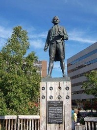 This is the front of Captain James Cook's statue located in Anchorage, Alaska. He stands tall and looks onto the sea, as he did on his ships. The visitors of the statue must look up to the famous man, which shows signs of intelligence and confidence.