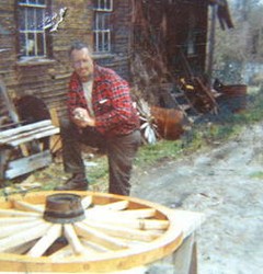 Ben Thresher admiring one of his wagon wheels which was crafted within his mill.