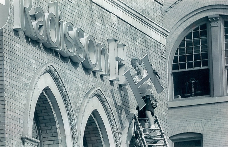 A worker removes the Radisson sign from the Americus in 1994.  