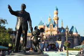 A statue of Walt Disney stands near the Sleeping Beauty Castle