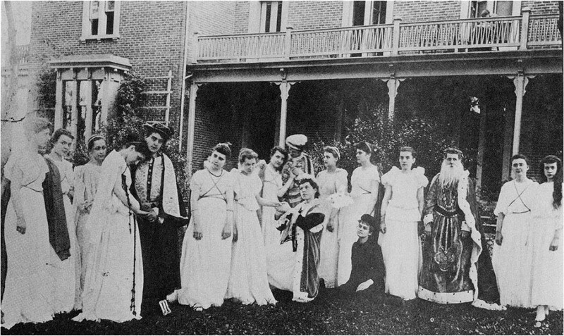 Irving College students dressed for a play standing in front of Irving Hall in 1900.