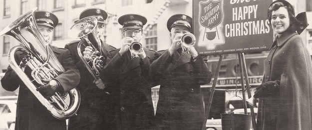 The Salvation Army Brass Band playing alongside a collection kettle, now a symbol of the Salvation Army's charitable efforts during the Christmas season