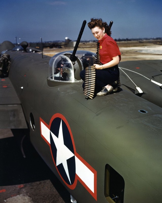 A World War II "Rosie" testfires the gun of one of the aircraft produced by the factory