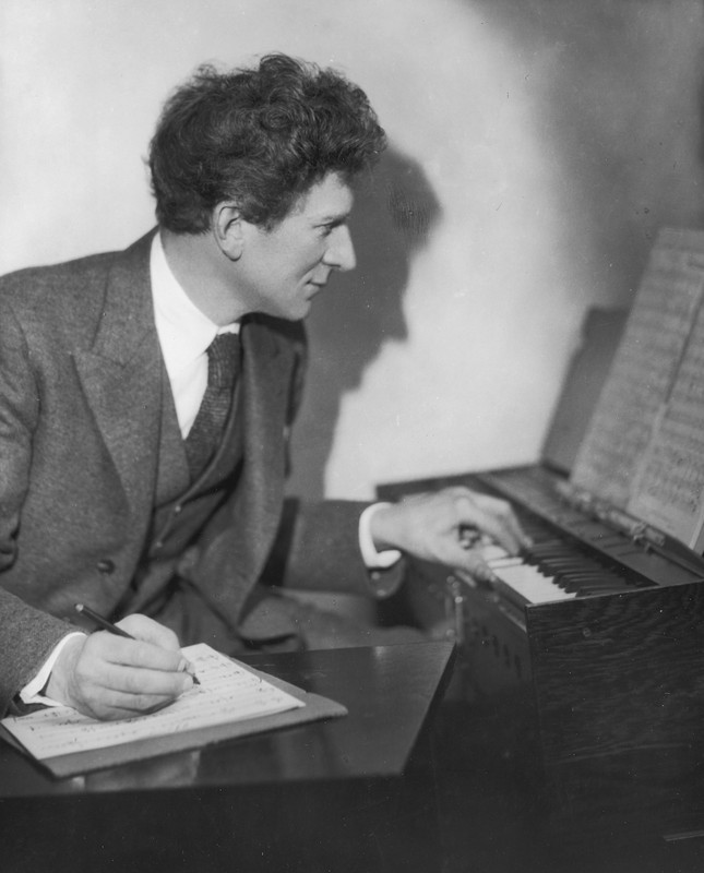 Percy Grainger practicing music in his home and studio