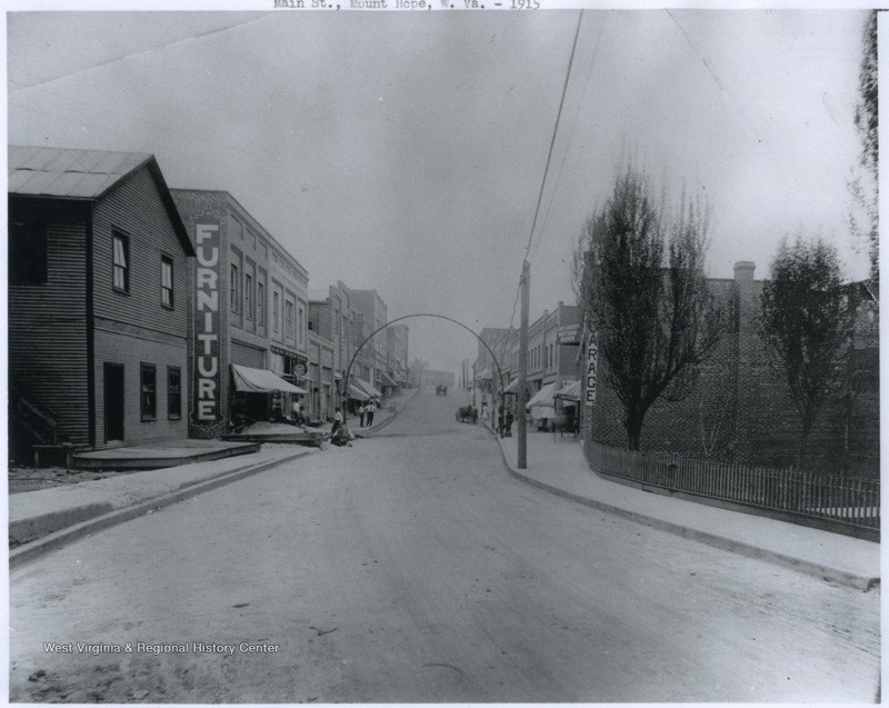 Hardware store can be seen with "Furniture" sign painted on building's edge. Main Street - 1915.