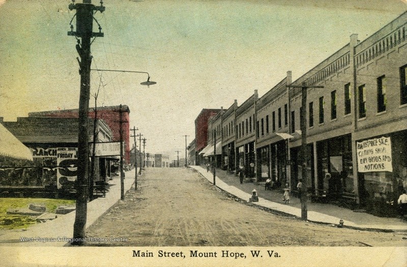 Postcard showing Garret and McNabb Block newly rebuilt.  Rubble from post fire can still be seen on the West side of Main St. Ca. 1912.