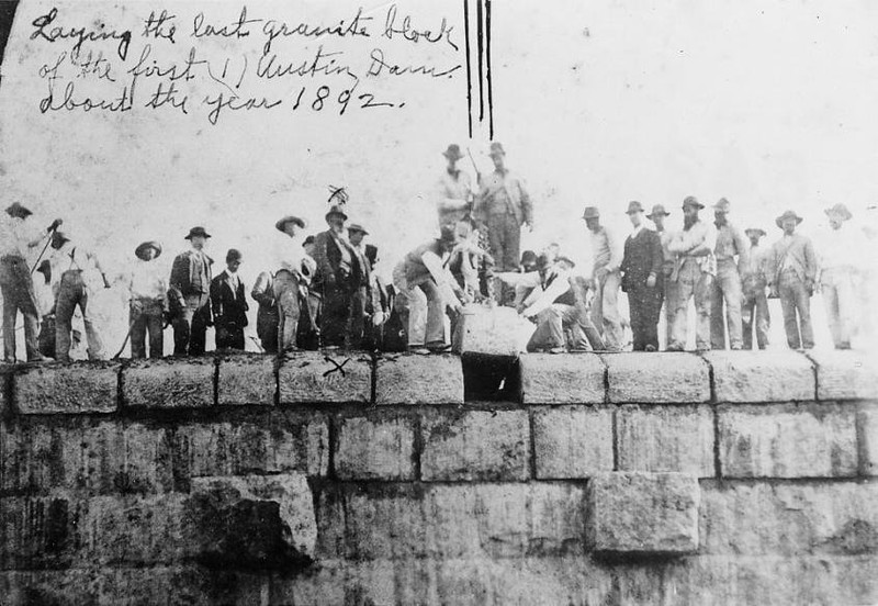 The final granite block being lowered into the Austin Dam, 1892. Photo from LCRA.