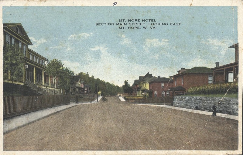 Post card of street view of the former Mount Hope Hotel (left) now known as the Mountainair Hotel. Notice how the porch is elevated away from Main St.