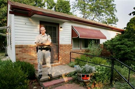 A police officer stands in front of Rader’s house, located at 6220 Independence St. Park City, Kansas. The house was auctioned off to Michelle Borin at the price of $90,000 in 2005. It was later demolished by the city in 2007.