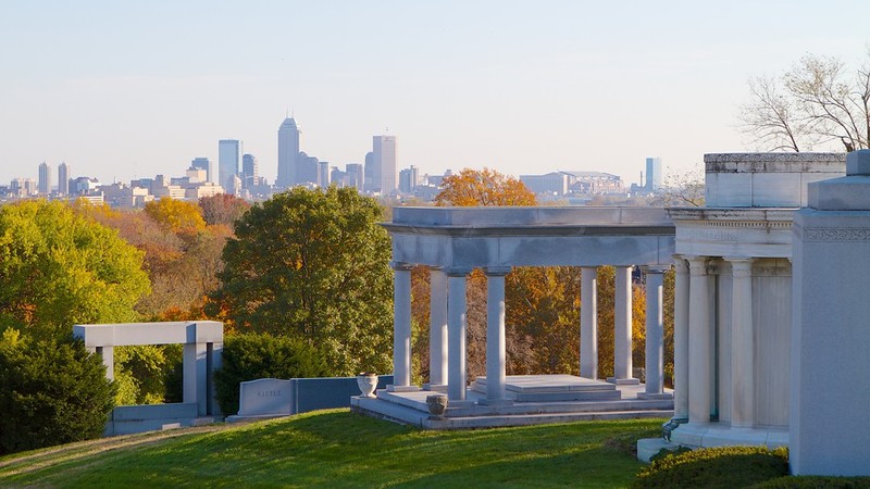 This photo shows the Indianapolis skyline behind the James Whitcomb Riley Monument.  