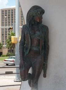 This is a statue of Selena. The statue is leaning against the wall, and it is on the right side of the monument.