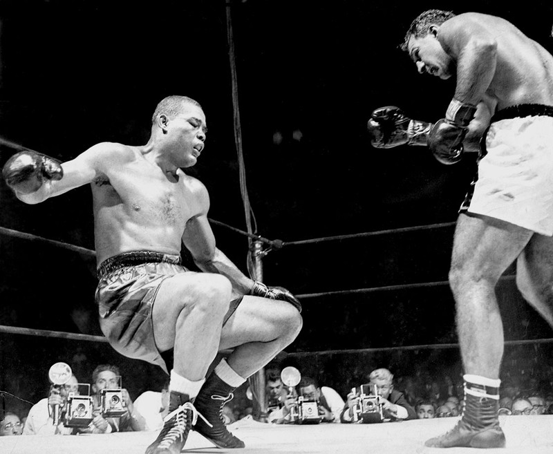 This photo was captured after Rocky Marciano knocked out Joe Louis in the 8th round of Louis' last fight. Marciano knocked him through the ropes in that final blow.