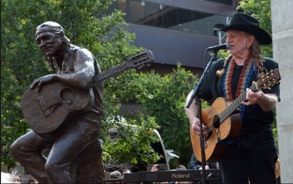 Willie Nelson performing beside of his statue in Austin, TX during the unveiling. 