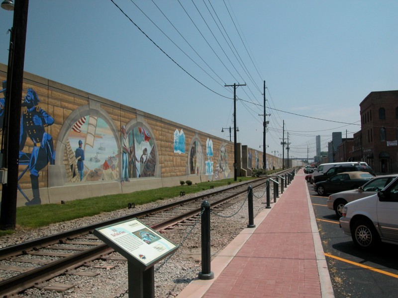 The floodwall features murals on both sides and many murals have interpretive signs explaining the person or event being depicted.