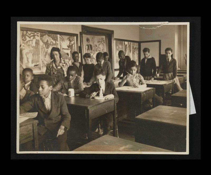 Students sculpting in a classroom with classmates and teacher.