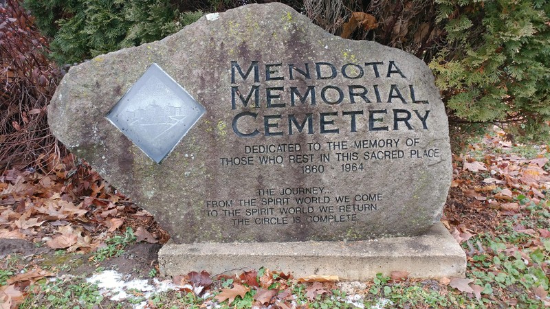 Close up of stone, which bears a picture of the original Mendota State Hospital and a poem.