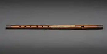 Maple, tipped with metal on both ends. Fife thinnest at tips, widest at mouth hole. Tips are covered with brass pieces which fit over wood. Tips each have five incised lines. Fife has mouth hole and six finger holes. Both ends open, but mouth hole end has cork inside. Wood varnished. Wood grain has curly pattern to it.