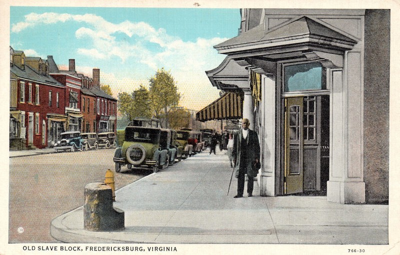 "Old Slave Block" postcard from the 1920s, depicting Albert Crutchfield standing in front of the Planters' Hotel and near the slave auction block on which he was sold around 1859