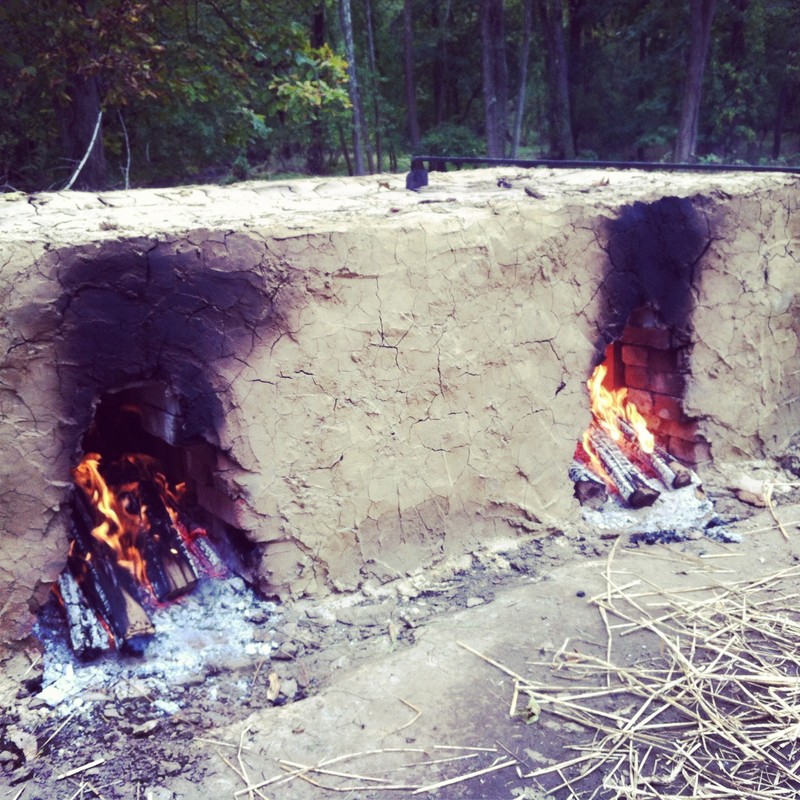 Image of a clay structure with two fires burning inside openings on the front