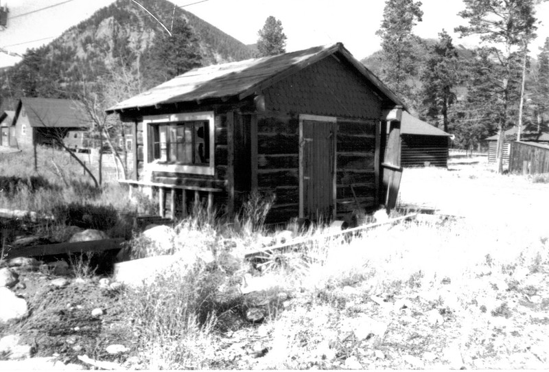 The Trapper's Cabin at its original location in the alley between Fifth and Sixth Avenues on the north side of Main Street.