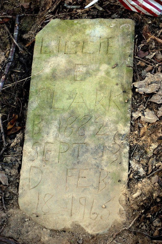 Hand-scratched headstone of Lillie E. Clark (1882-1965) found sunken in the earth during cleanup efforts in 2013