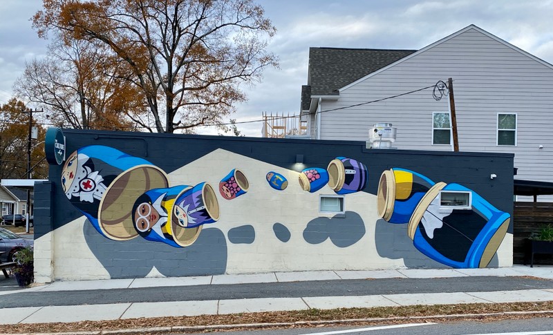 A series of nesting dolls are painted across the exterior wall of a business.