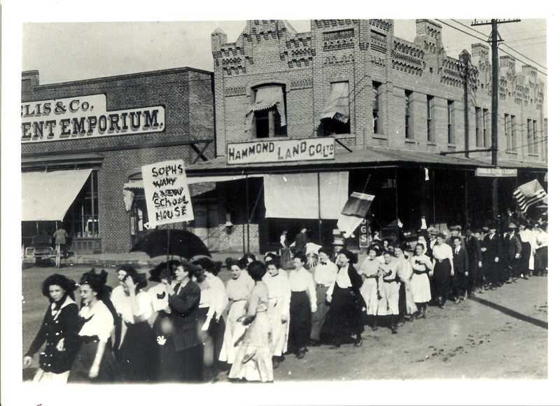 Boos Building in the background during a march for a new schoolhouse (no date).