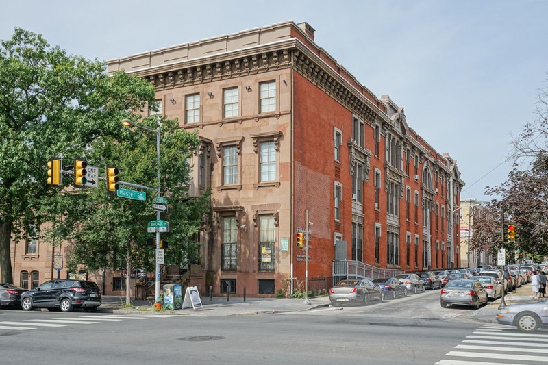 Edwin Forrest House and intersection of Market and Broad Streets on a sunny day in spring or summer, with trees in front of the Broad Street façade.