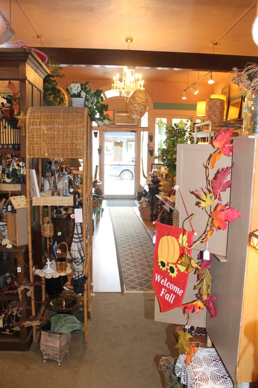 A bright showroom, with the glass front door at center. Many colorful houseware items are displayed for sale.