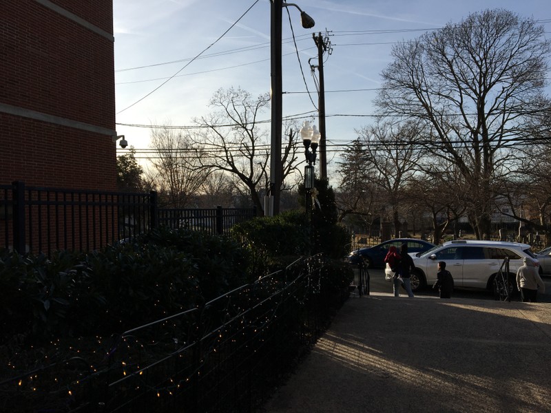 View leaving the church after an 8am mass in December, cemetery gates open and a car-filled Morris St.