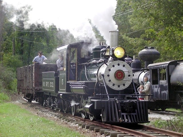 Steam and diesel locomotives run on a narrow gauge track.