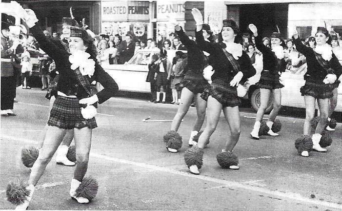 HEHS cheerleaders march by The Peanut Shoppe in 1967