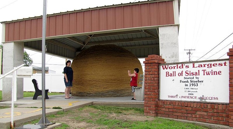 Another picture of the World's Largest Ball of Twine in the shelter that the Cawker City built and paid for and tourist taking pictures with it.