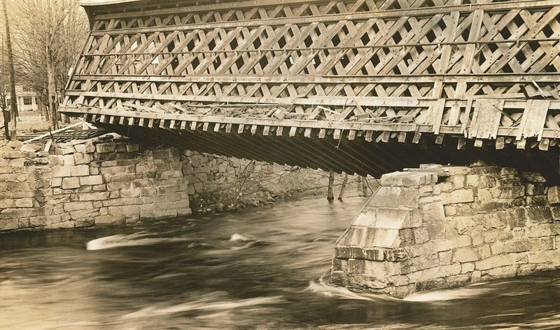 Image of the covered railroad bridge in Contoocook after it was tipped during the 1938 hurricane.  